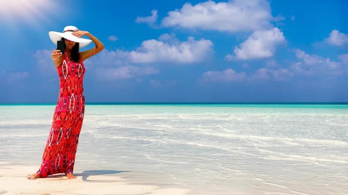A person in a red dress standing on a beach
Description automatically generated with medium confidence